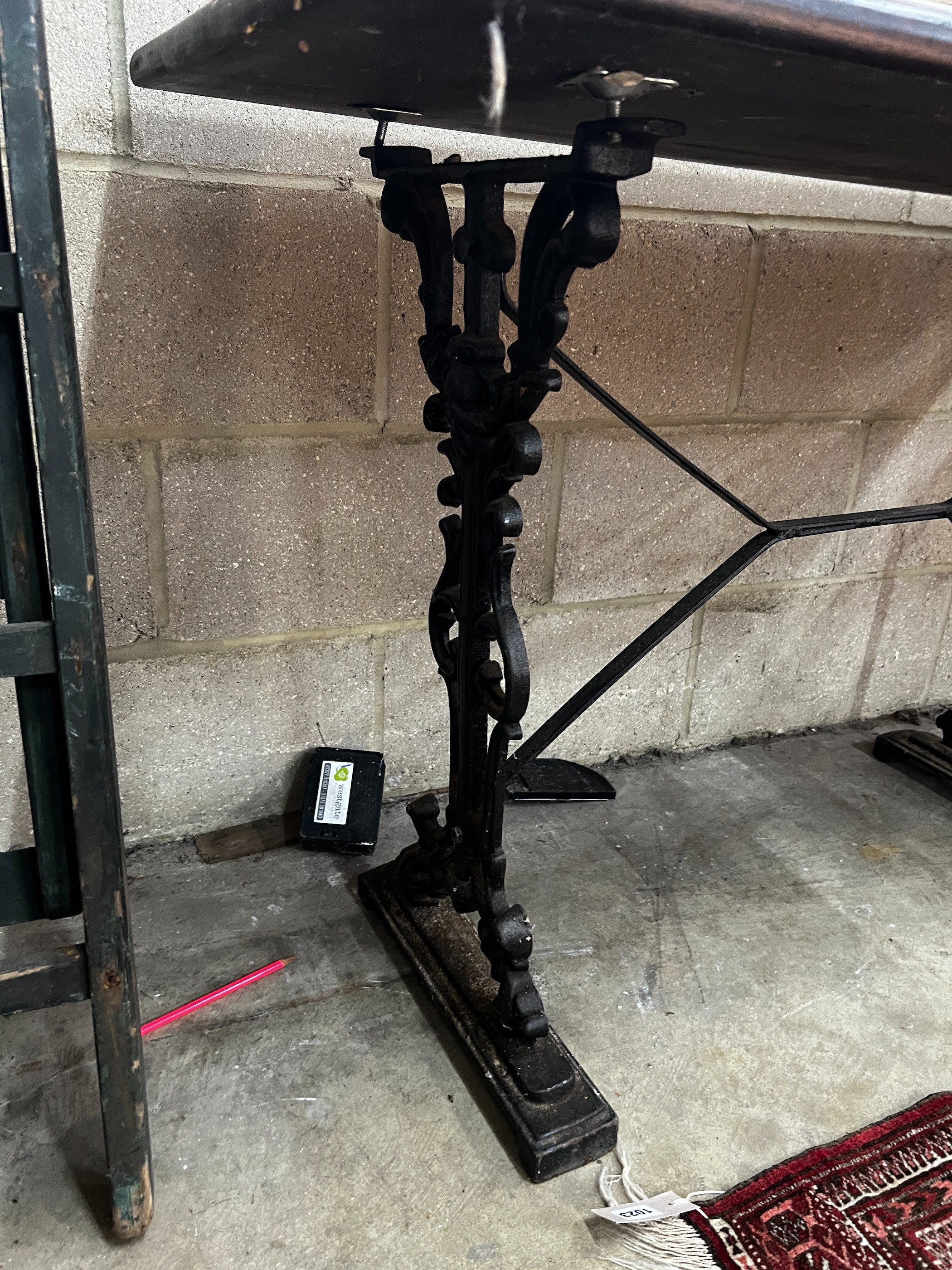 Two Victorian style cast metal stained wood topped tavern tables, larger width 120cm, depth 60cm, height 75cm